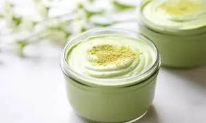 Cremiges Matcha-Dessert in einem Glas, bestreut mit feinem Matcha-Pulver. Ein Hauch von Frische und Grün.