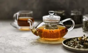 Glas-Teekanne mit schwarzem Tee, der dampft. Ist schwarzer Tee gut zum Abnehmen? Ja, er kann helfen.