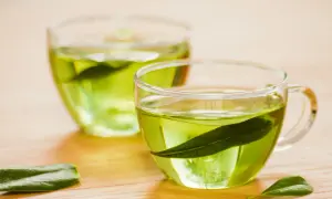Zwei Gläser mit grünem Tee, welcher Tee regt den Stoffwechsel an? Grüner Tee mit Blättern.