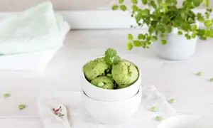 Schalen mit cremigem Matcha-Eis, garniert mit Koriander und Erbsen. Ein erfrischender Genuss!