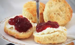 Zwei Scones mit Clotted Cream und Marmelade auf einer Etagere, perfekt für ein Cream Tea Rezept.