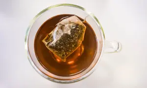 Eine Tasse Tee mit Teebeutel. Die klare Flüssigkeit und der Teebeutel lassen die ctc bedeutung erahnen: ein starker, aromatischer Genuss.
