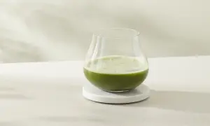 Ein Glas erfrischender cold brew matcha steht auf einem Marmorsubstrat.