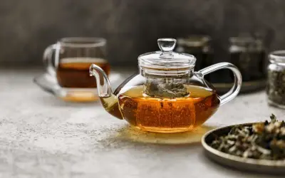 Glas-Teekanne mit schwarzem Tee, der dampft. Ist schwarzer Tee gut zum Abnehmen? Ja, er kann helfen.