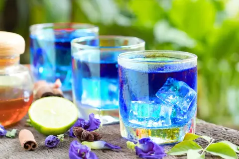 Erfrischender Anchan Tee mit Eiswürfeln, Limette und Zimt. Die Zubereitung ist einfach und das Ergebnis ein visuell beeindruckendes Getränk.