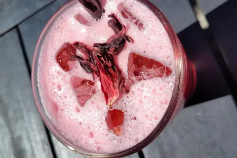 Erfrischendes Hibiskusgetränk mit Eis und getrockneten Blüten. Perfekt für leichte Hibiskus Rezepte.