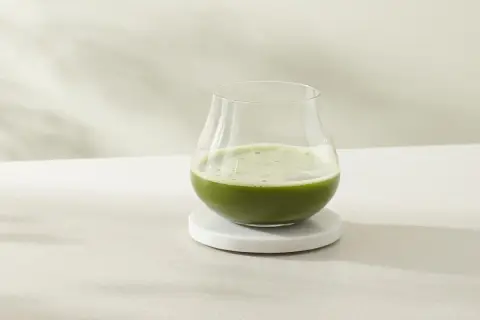Ein Glas erfrischender cold brew matcha steht auf einem Marmorsubstrat.