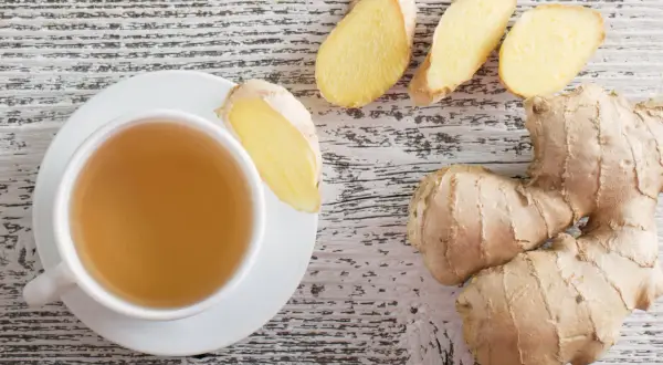 Eine Tasse Tee mit Ingwerscheiben. Die pfefferminztee mit ingwer wirkung ist bekannt für ihre wohltuenden Eigenschaften.