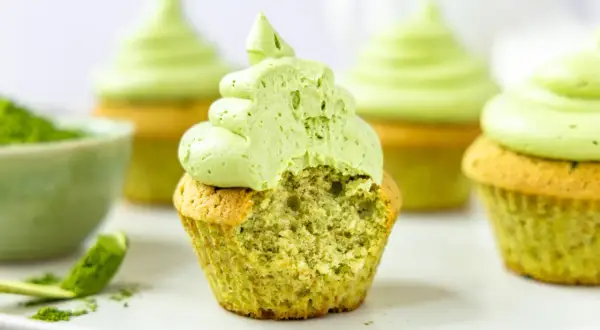 Saftige matcha cupcakes mit fluffigem Topping. Ein Bissen verrät die köstliche grüne Füllung.