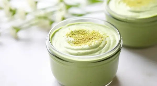 Cremiges Matcha-Dessert in einem Glas, bestreut mit feinem Matcha-Pulver. Ein Hauch von Frische und Grün.