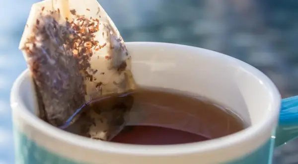 Ein Teebeutel zieht in einer Tasse Tee. Nachhaltig denken: teebeutel wiederverwenden für mehr Genuss.