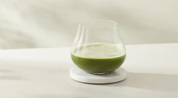 Ein Glas erfrischender cold brew matcha steht auf einem Marmorsubstrat.