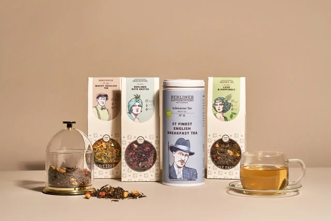Verschiedene Teesorten alphabetisch geordnet: Kräutertee, aromatisierter Früchtetee, schwarzer Tee und grüner Tee. Daneben eine Teetasse mit Aufguss.