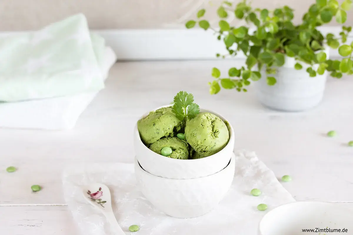 Schalen mit cremigem Matcha-Eis, garniert mit Koriander und Erbsen. Ein erfrischender Genuss!