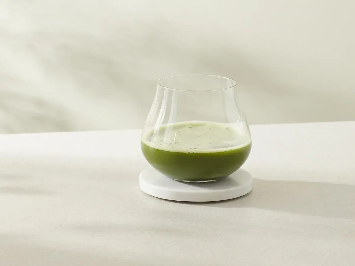Ein Glas erfrischender cold brew matcha steht auf einem Marmorsubstrat.