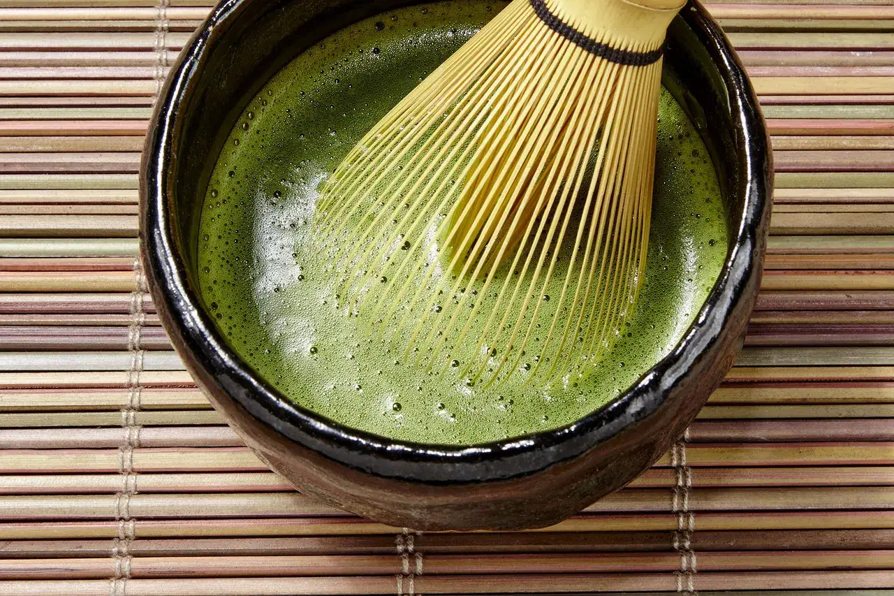 Matcha-Schale mit Chasen, der traditionellen Bambus-Schneebesen, der die gr&uuml;ne Fl&uuml;ssigkeit aufsch&auml;umt. Dieser belebende Trank macht matcha wach.
