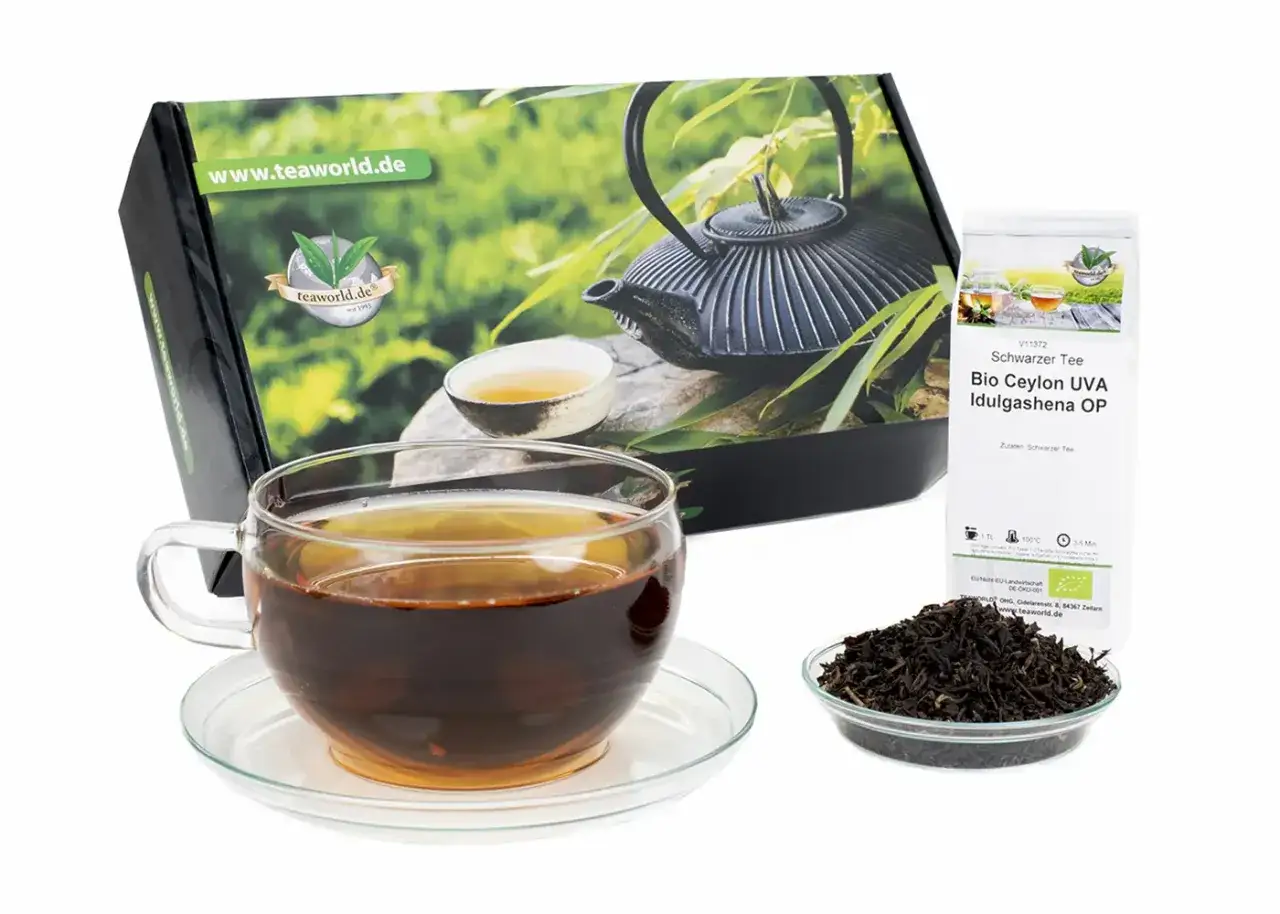 Ein Glas schwarzer Tee, daneben eine Schale mit losem Tee und eine Packung Bio Ceylon Tee. So schmeckt schwarzer Tee!