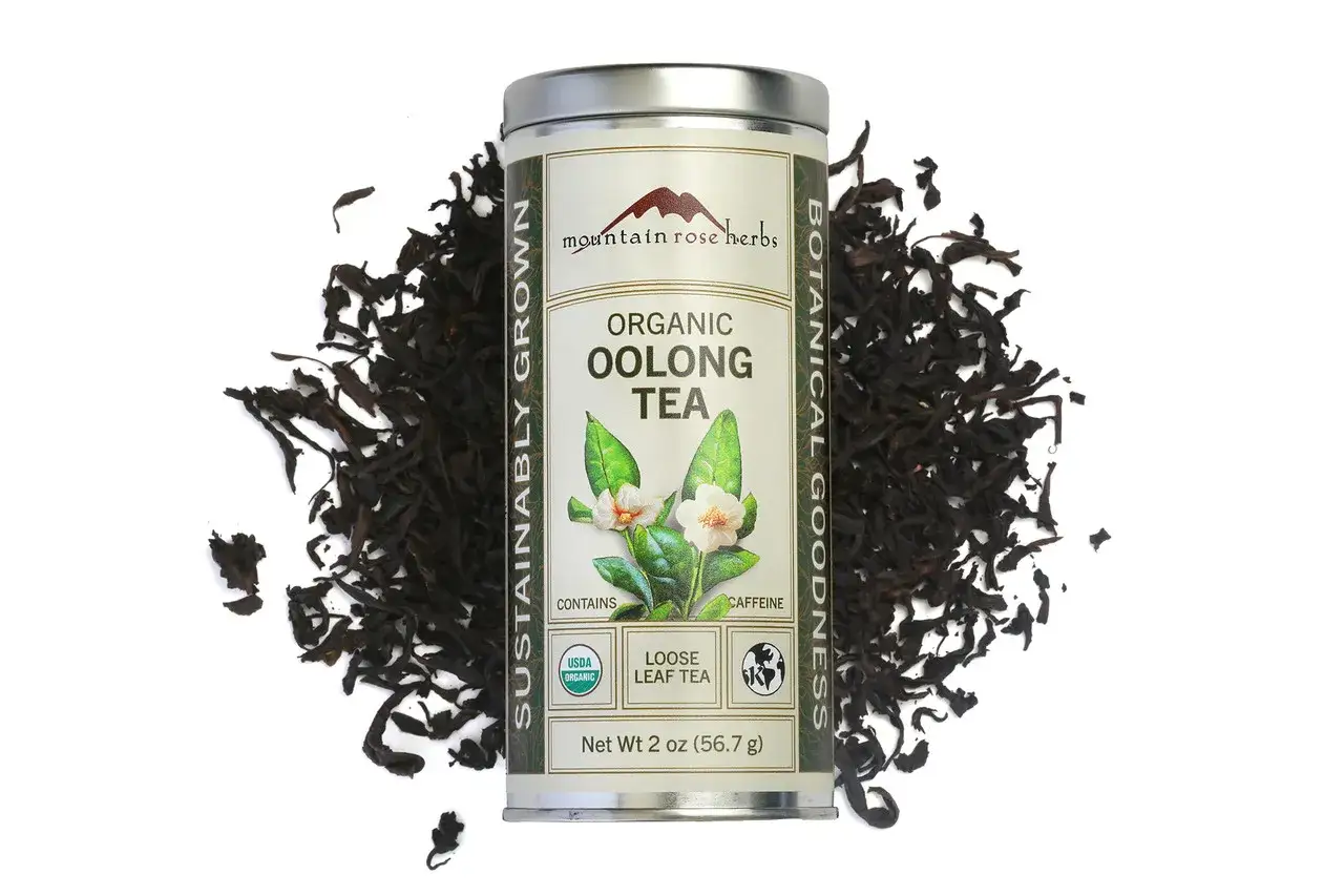 Ein Blech mit losem Bio-Oolong-Tee, umgeben von trockenen Teeblättern. Was ist ein Tee? Eine Frage, die sich mit diesem aromatischen Genuss beantwortet.