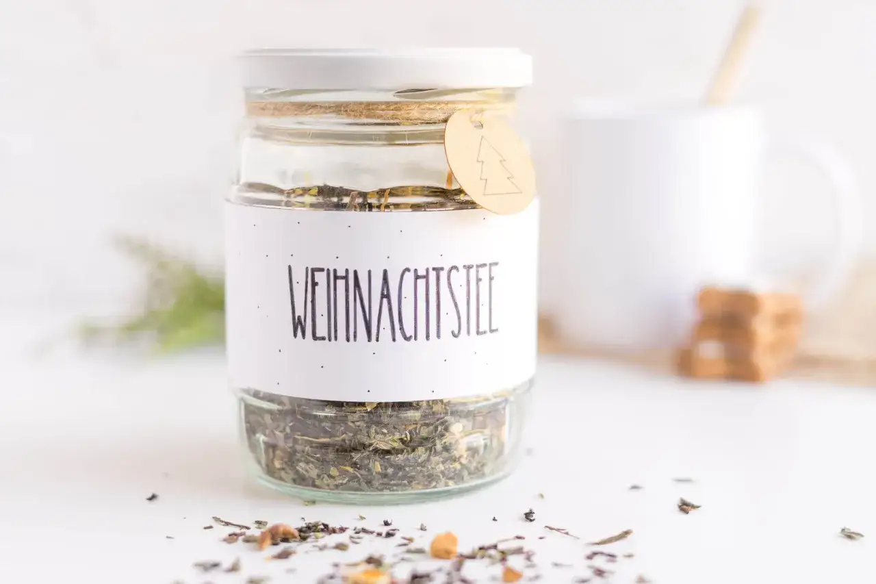 Glas mit selbstgemachtem Weihnachtstee, perfekt zum Verschenken. Ein Anh&auml;nger mit Tannenbaum ziert das Etikett.