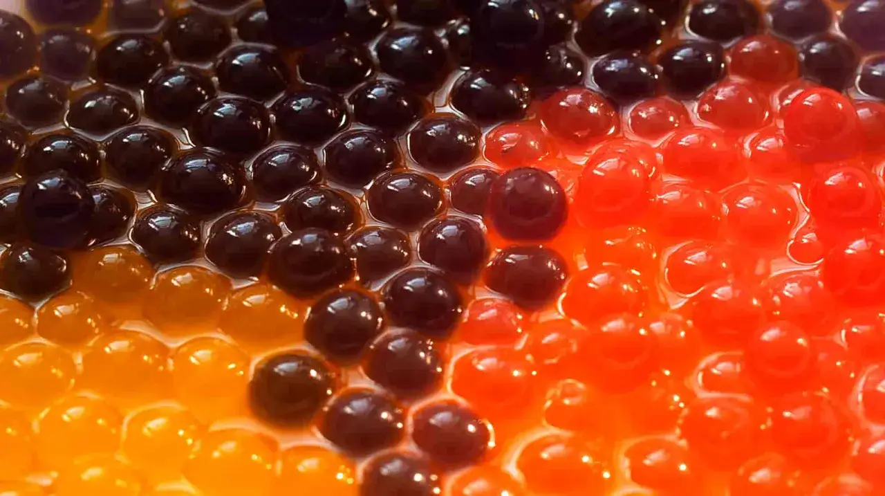 Bunte Tapiokakugeln in leuchtenden Farben, die auf einen erfrischenden Kick mit Bubble Tea Koffein warten.