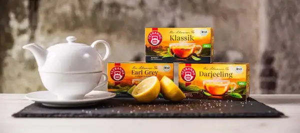 Weiße Teekanne, Zitrone und Teekanne-Packungen: Klassik, Earl Grey, Darjeeling. Eine Tee-Wirkung-Tabelle wäre hier passend.