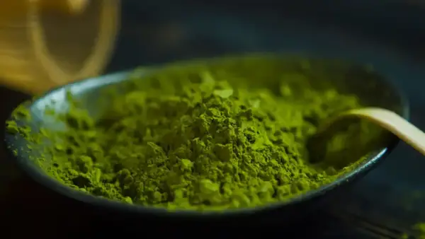 Feines, leuchtend grünes Matcha-Pulver in einer Schale, bereit für einen Energieschub durch den enthaltenen Matcha-Koffein.