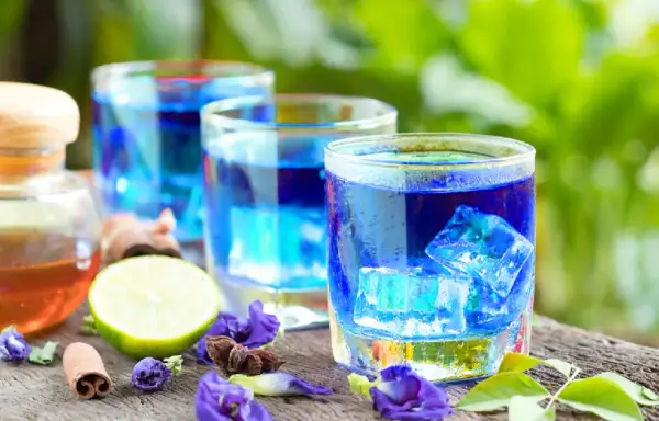 Erfrischender Anchan Tee mit Eiswürfeln, Limette und Zimt. Die Zubereitung ist einfach und das Ergebnis ein visuell beeindruckendes Getränk.